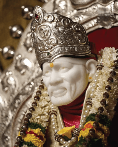 Sai baba photo from one side angle, wearing rudraksha beads, flowers, & other attractive wear with tilak.